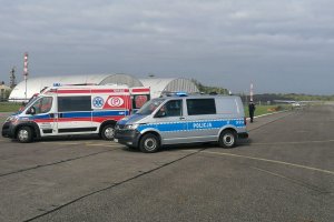 Widok na pojazdy służb ratowniczych stojących na płycie lotniska podczas ćwiczeń