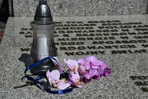 Zdjęcie kolorowe. Widoczny znicz przed Grobem Policjanta Polskiego w Komendzie Wojewódzkiej Policji w Katowicach