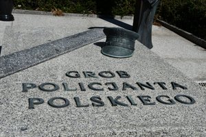 Zdjęcie kolorowe. Widoczny znicz przed Grobem Policjanta Polskiego w Komendzie Wojewódzkiej Policji w Katowicach