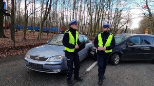 Zdjęcie kolorowe. Policjanci na miejscu zdarzenia drogowego
