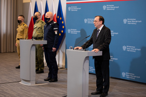 Konferencja prasowa dotycząca programu modernizacji służb mundurowych. Na zdjęciu Minister Spraw Wewnętrznych i Administracji podczas przemówienia, w tle Komendant Główny Policji oraz pozostali uczestnicy.