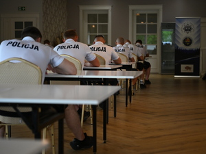 zdjęcie policjantów siedzą przy stolikach podczas konkurencji
