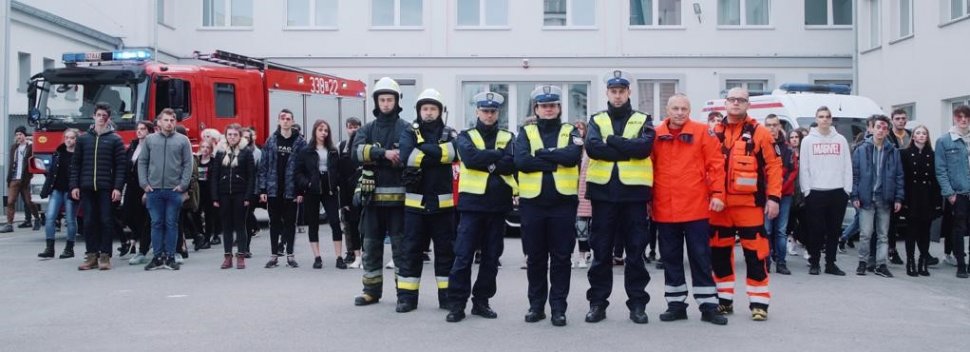 Policjanci, strażacy, ratownicy medyczni i uczniowie szkoły na wspólnym zdjęciu