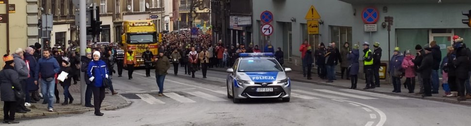 Policyjny radiowóz jedzie na czele świątecznego korowodu.