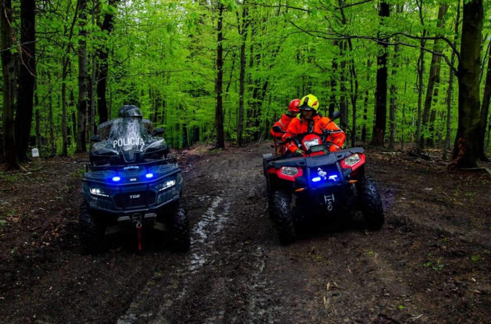 Policjanci i strażacy pożarni jadą swoimi quadami przez las