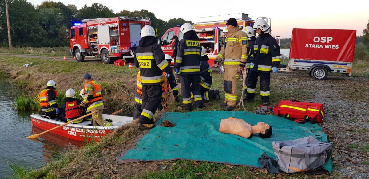 Policjanci i strażacy trenują udzielanie pierwszej pomocy na fantomach. Zdjęcie wykonane nad jeziorem