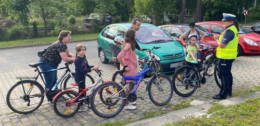 Policjantka z ruchu drogowego rozmawia z grupką rowerzystów.