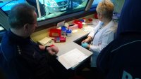 Pielęgniarka przeprowadza wywiad z policjantem przed oddaniem krwi.