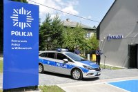 na zdjęciu policjanci prowadzący uroczystość oraz oznakowany radiowóz zaparkowany przed wejściem nowego posterunku