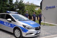 na zdjęciu oznakowany radiowóz zaparkowany przed posterunkiem oraz policjanci prowadzący uroczystość