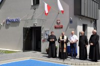 na zdjęciu księża przed wejściem do posterunku