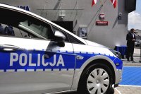 na zdjęciu policyjny radiowóz oraz przemawiający wojewoda śląski