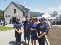 Policjantki stoją przed posterunkiem z niepełnosprawnym mężczyzną i jego matką.