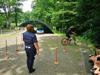 Policjantka z ruchu drogowego prowadzi zajęcia na torze przeszkód.