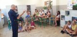 Policjant prowadzi prelekcję z młodzieżą.