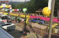 Policyjny radiowóz jedzie trasą przejazdu wyścigu kolarskiego.