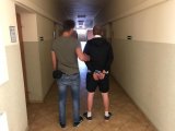 Policjant trzyma zatrzymanego 36-latka.