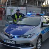 Kom. Krzysztof Stankiewicz stoi przy pojeździe służbowym.
