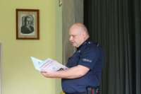 Policjant czyta książeczkę.