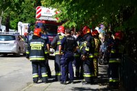 Policjanci i strażacy w stoją w rejonie zawalonej budowli.