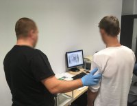 Technik kryminalistyki pobiera odciski palców.