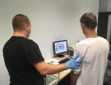 Technik kryminalistyki pobiera odciski palców.