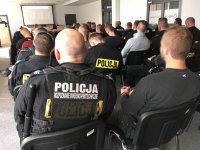 Policyjny pirotechnik oraz funkcjonariusz operacyjny na sali odpraw.