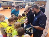 Policjant i policjantka prowadzą konkurs dla dzieci.