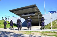 Policjanci obserwują wychodzących z pociągu kibiców.
