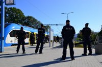 Policjanci z oddziałów prewencji obserwują rejon wejścia na peron kolejowy.