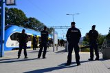 Policjanci z oddziałów prewencji obserwują rejon wejścia na peron kolejowy.