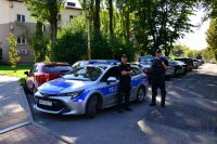Patrol Policji zabezpiecza ulicę i parking przy stadionie.