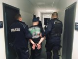 Policjanci prowadzą zatrzymanego.