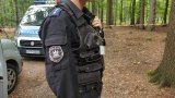 Policyjny pirotechnik stoi przy radiowozie.