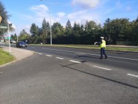 Policjant z drogówki zatrzymuje pojazd do kontroli.