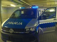 Policyjny radiowóz, w środku kierowca i pasażer.
