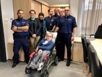 Policjanci i niepełnosprawni Patryk i Dawid z rodzicami w gabinecie komendanta.