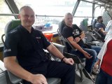 Policjant w mundurze oddaje krew, na drugim planie krew oddają policjanci w ubiorach cywilnych.