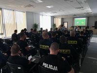 Policjanci siedzą na sali konferencyjnej bielskiej komendy podczas zabezpieczenia meczu piłkarskiego.