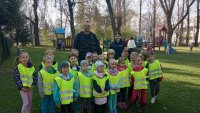 Policjanci i dzieci ubrane w kamizelki odblaskowe na wspólnym zdjęciu.