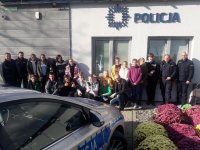 Uczniowie i policjanci na wspólnym zdjęciu przed posterunkiem policji.