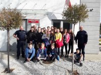 Uczniowie i policjanci na wspólnym zdjęciu przed posterunkiem policji.