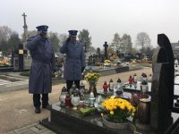 Policjanci oddają honor nad grobem poległego policjanta.