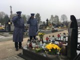 Policjanci oddają honor nad grobem poległego policjanta.