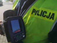 Policjant pokazuje wyświetlacz ręcznego miernika prędkości.