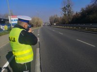 Policjant mierzy prędkość pojazdów przy użyciu ręcznego miernika prędkości.