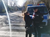 Dziennikarka prowadzi wywiad z policjantem podczas zabezpieczenia rejonu cmentarza.