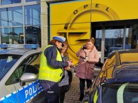 Policjantka rozmawia z kierującą, w tel dziennikarka radiowa.