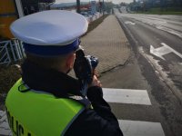 Policjant mierzy prędkość jadących pojazdów.
