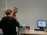 Technik kryminalistyki pobiera od zatrzymanej odciski palców.